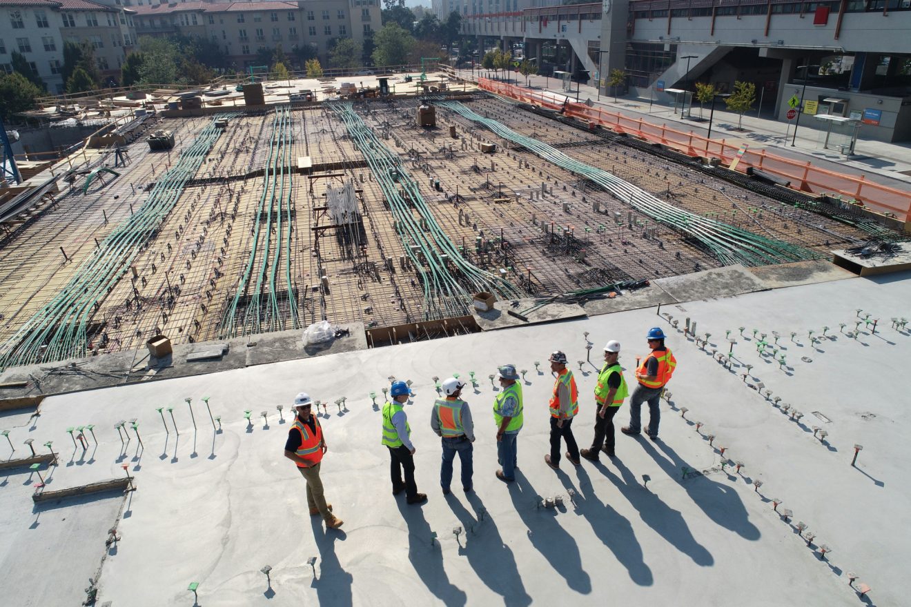 A team of construction workers looks out on the build site.