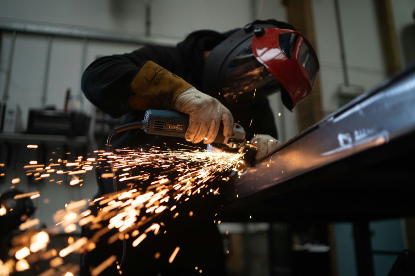 A person maintains a piece of manufacturing equipment