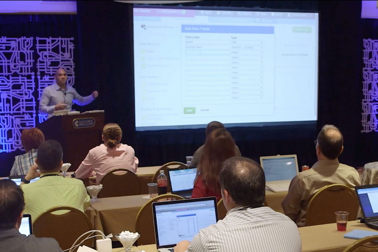 A man presenting in front of an audience.