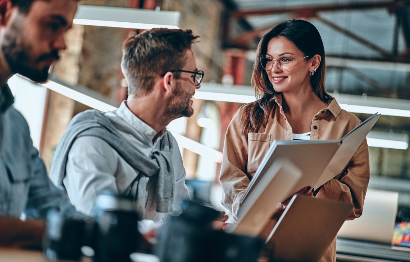 Two people in an office setting discuss notes