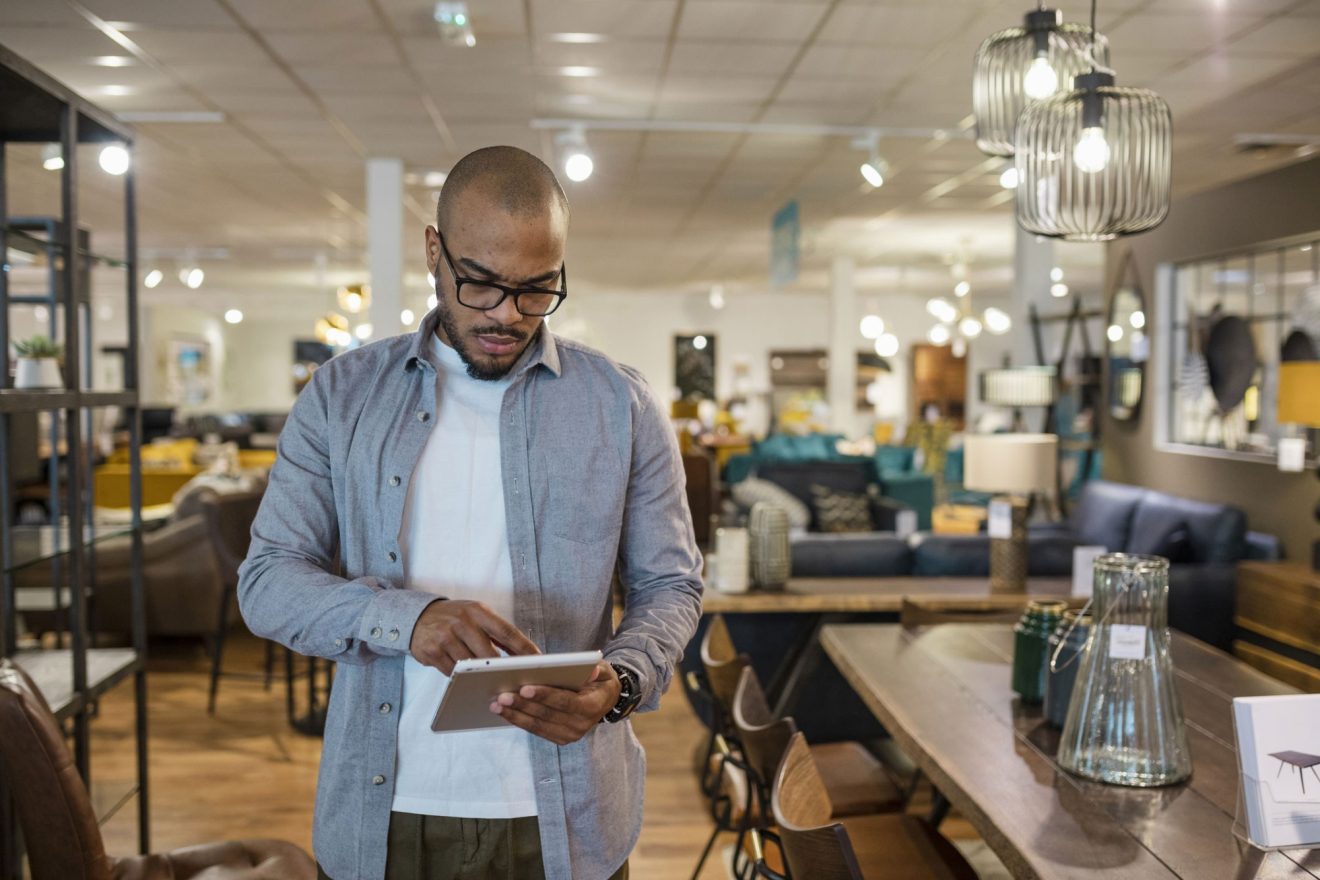 A man in his shop references Quickbase on his tablet