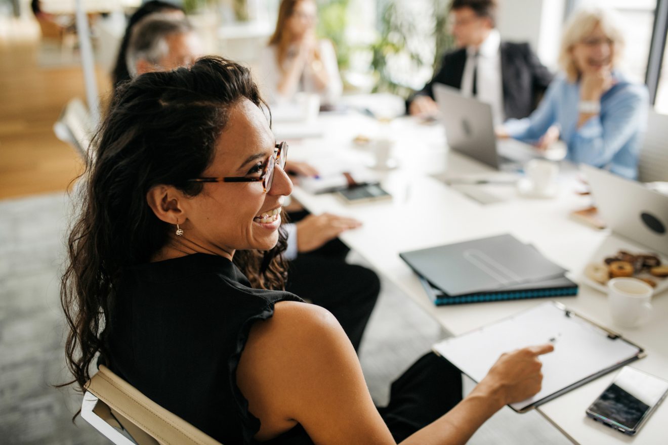 A person laughs at a meeting with her peers