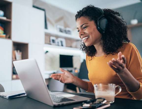 A woman collaborates with her coworkers over a video call