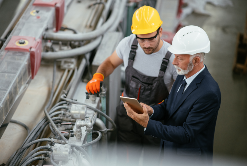 Two men in hard hats on manufacturing floor